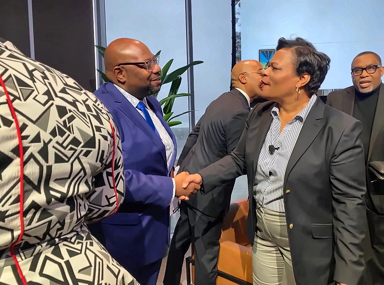 Kermit Williams shaking hands with a woman at a panel event